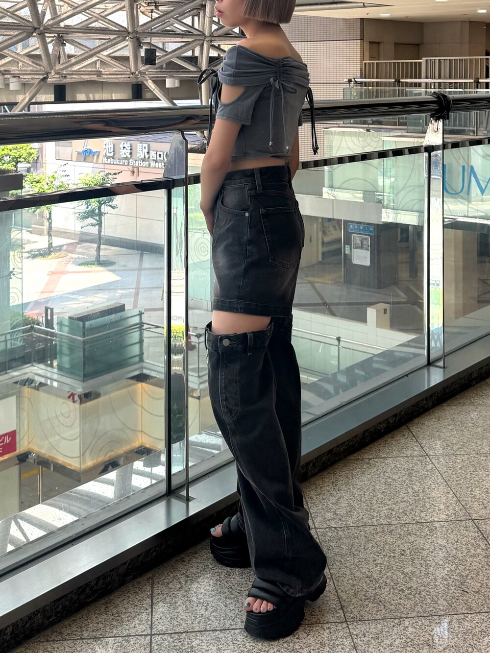 グレー系のTシャツ/カットソー、ブラック系のデニムパンツ、ブラック系のサンダルを着用したレディースの夏コーディネートの2枚目の写真