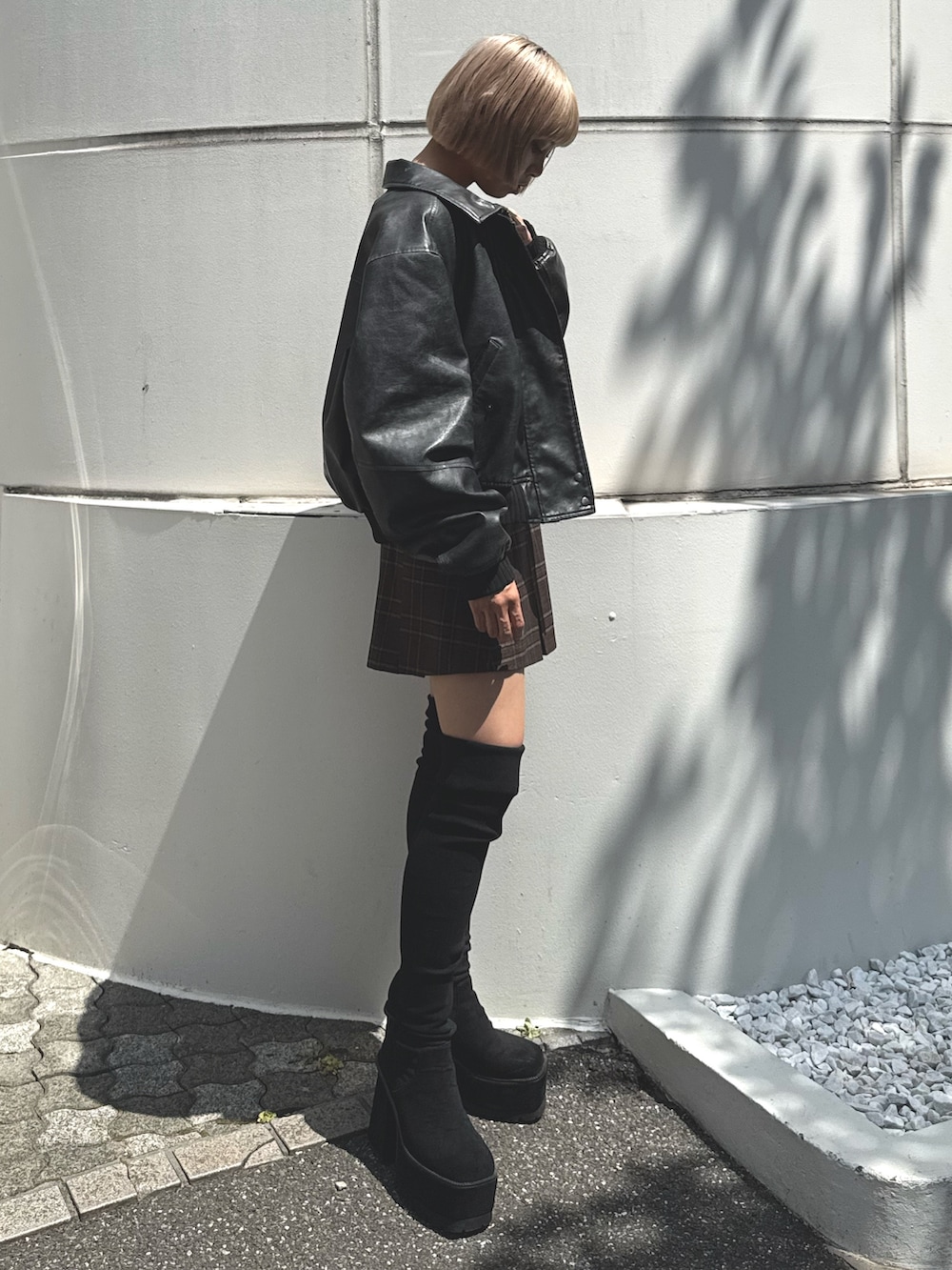 ブラック系のブルゾン、ブラック系のニット/セーター、ブラウン系のスカートを着用したレディースの秋コーディネートの3枚目の写真