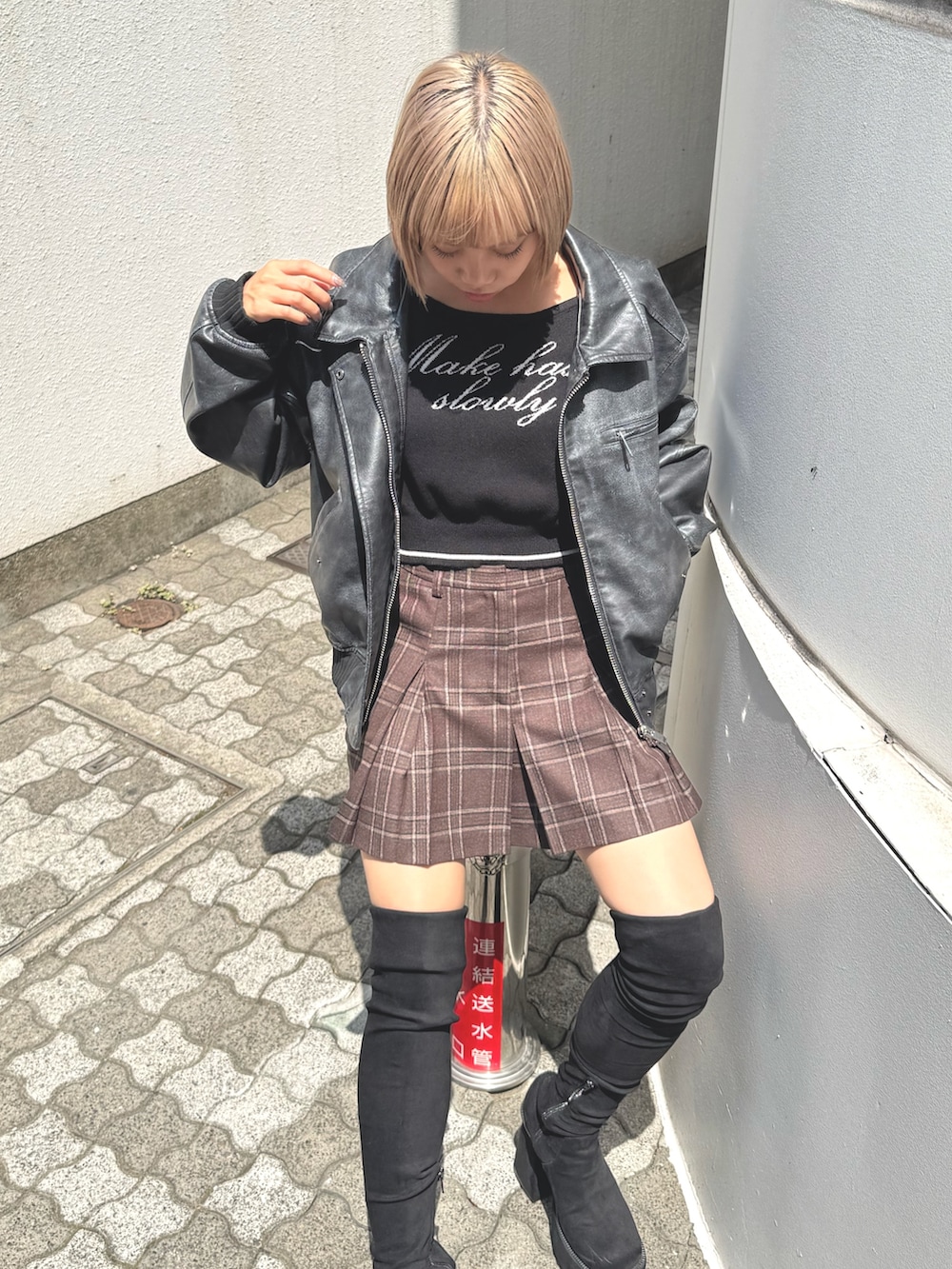 ブラック系のブルゾン、ブラック系のニット/セーター、ブラウン系のスカートを着用したレディースの秋コーディネートの4枚目の写真