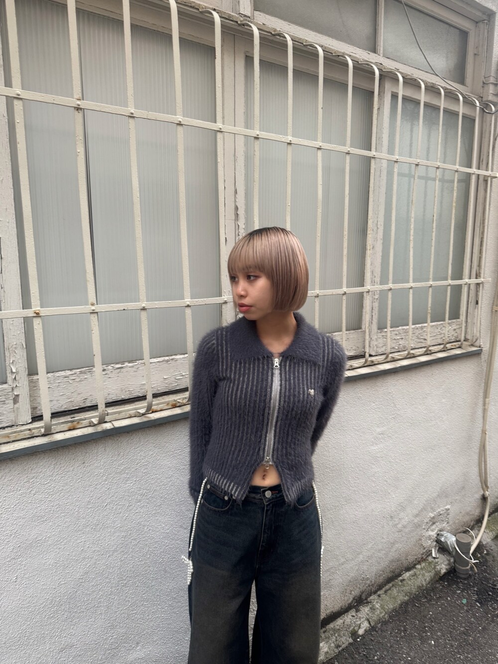 ブルー系のニット/セーター、ブルー系のデニムパンツ、ブラック系のブーツを着用したレディースの夏コーディネートの4枚目の写真