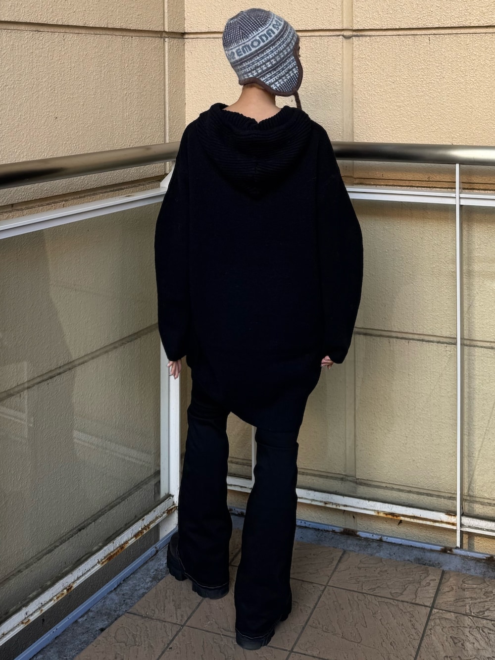 ブラック系のニット/セーター、ブルー系のデニムパンツ、ブラック系のブーツを着用したレディースの冬コーディネートの3枚目の写真