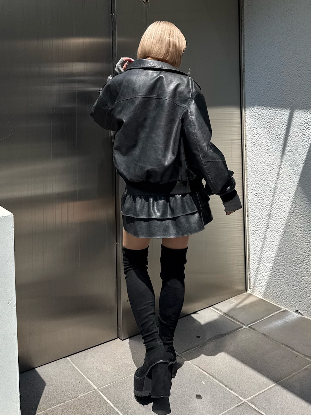 グレー系のブルゾン、グレー系のスカート、グレー系のニット/セーターを着用したレディースの秋コーディネートの3枚目の写真