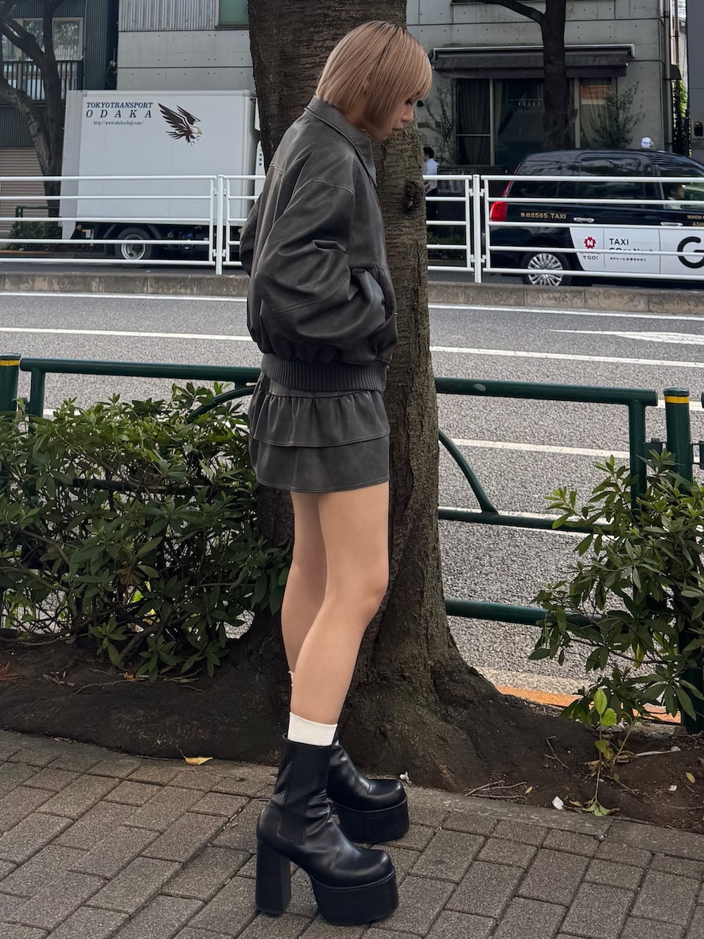 グレー系のブルゾン、グレー系のスカート、ブラック系のブーツを着用したレディースの秋コーディネートの2枚目の写真