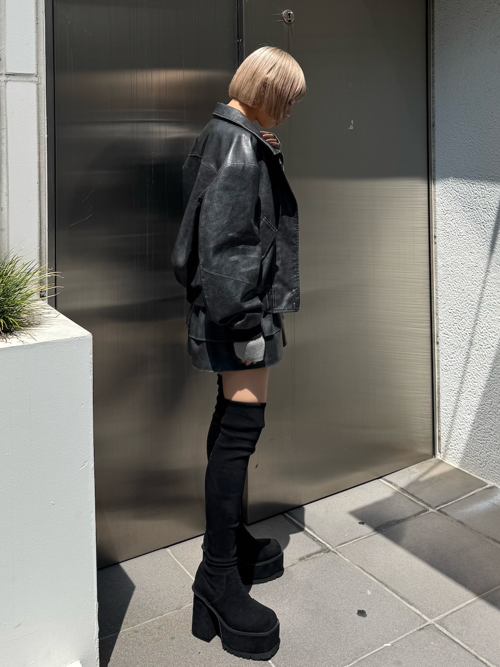 グレー系のブルゾン、グレー系のスカート、グレー系のニット/セーターを着用したレディースの秋コーディネートの2枚目の写真