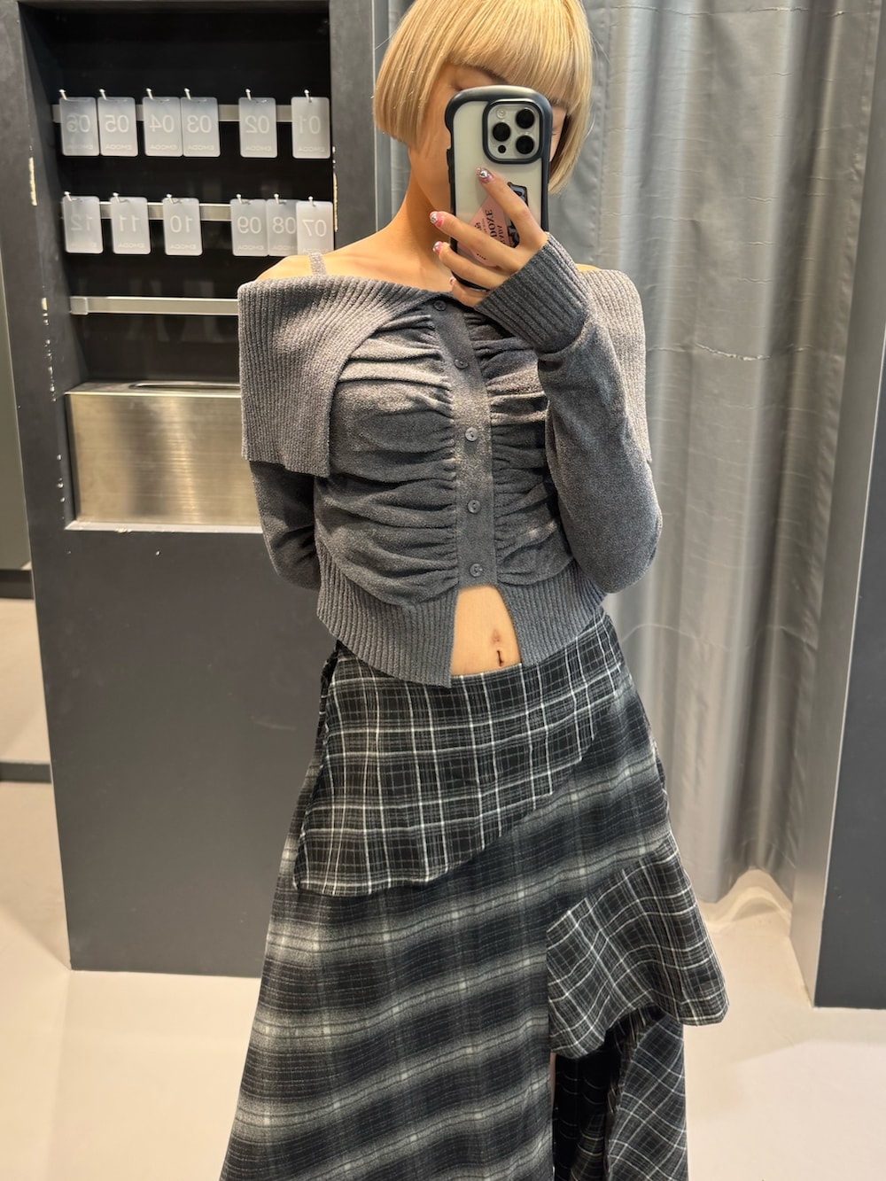 グレー系のニット/セーター、ブラック系のスカート、ブラック系のブーツを着用したレディースの秋コーディネートの3枚目の写真