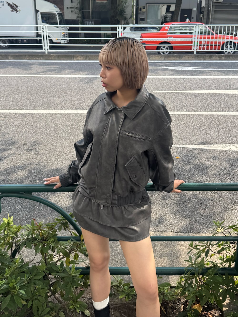 グレー系のブルゾン、グレー系のスカート、ブラック系のブーツを着用したレディースの秋コーディネートの4枚目の写真