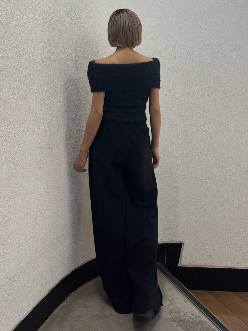 ブルー系のニット/セーター、ブラック系のスウェットパンツ、ブラック系のローファーを着用したレディースの秋コーディネートの3枚目の写真