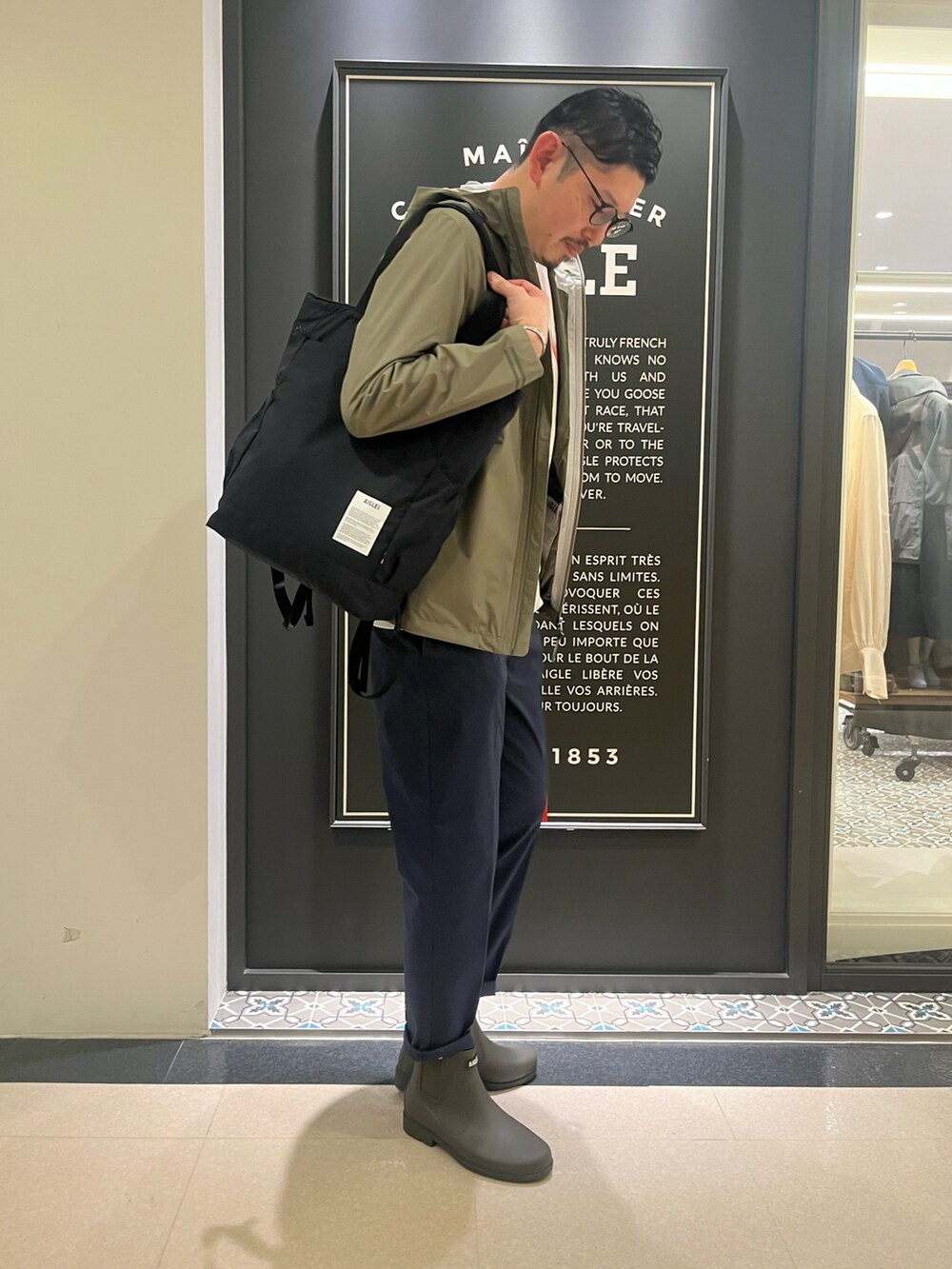 「トートバッグ、春コーデ、雨の日コーデ、大人カジュアル、レインブーツ」｜「AIGLEの透湿防水 フーデッドジャケット（マウンテンパーカー、グリーン系）」を使った、Yoshiさん（メンズ・181cm）の春コーディネートの4枚目の写真