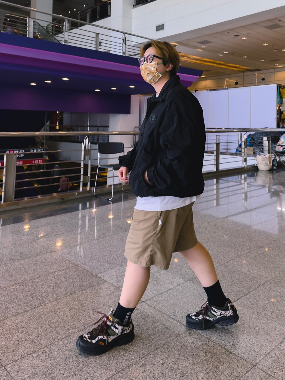 ベージュ系のパンツ、ホワイト系のナイロンジャケット、ブラック系のシューズを着用したレディースの春コーディネートの4枚目の写真