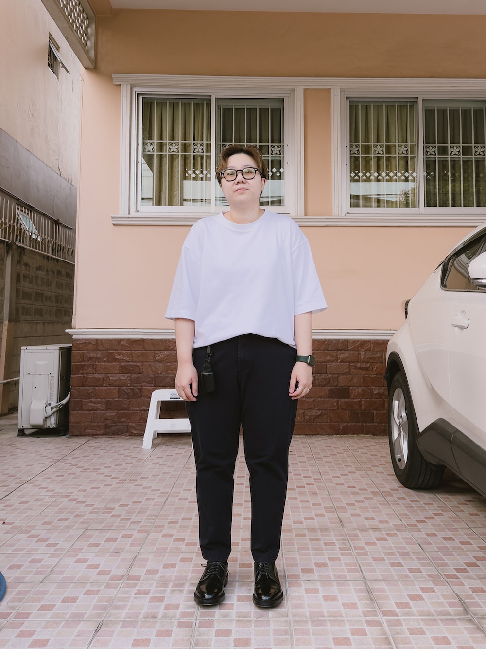 ホワイト系のTシャツ/カットソー、ブルー系のチノパンツ、ブラック系のドレスシューズを着用したレディースの春コーディネートの2枚目の写真