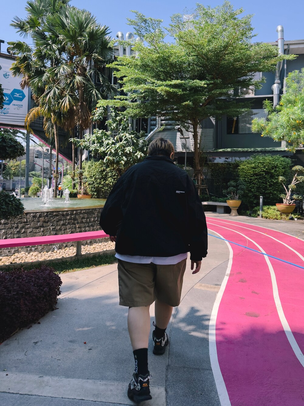 ベージュ系のパンツ、ホワイト系のナイロンジャケット、ブラック系のシューズを着用したレディースの春コーディネートの3枚目の写真