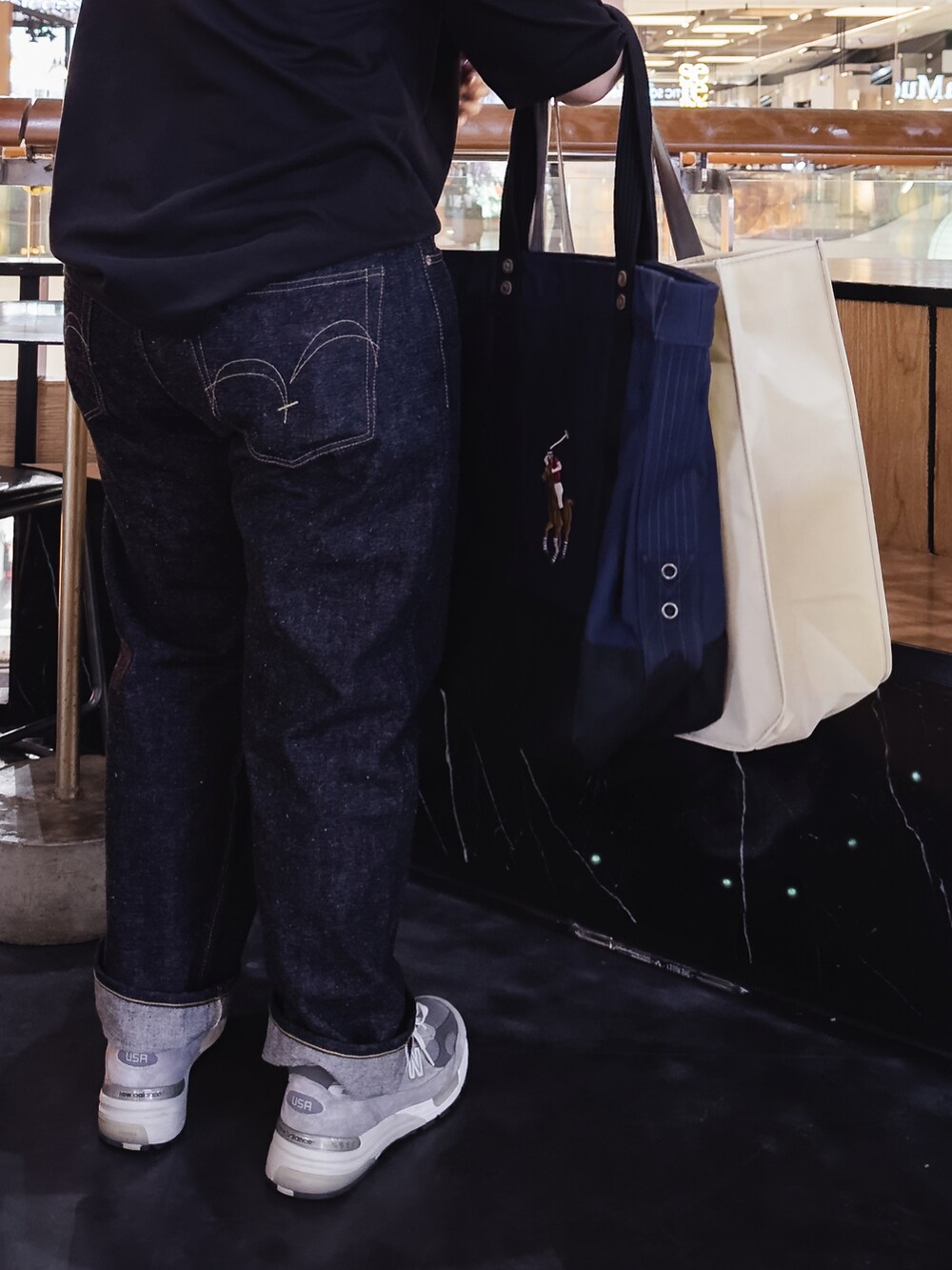 ブルー系のデニムパンツ、ブラック系のスニーカー、ホワイト系のTシャツ/カットソーを着用したレディースの冬コーディネートの3枚目の写真