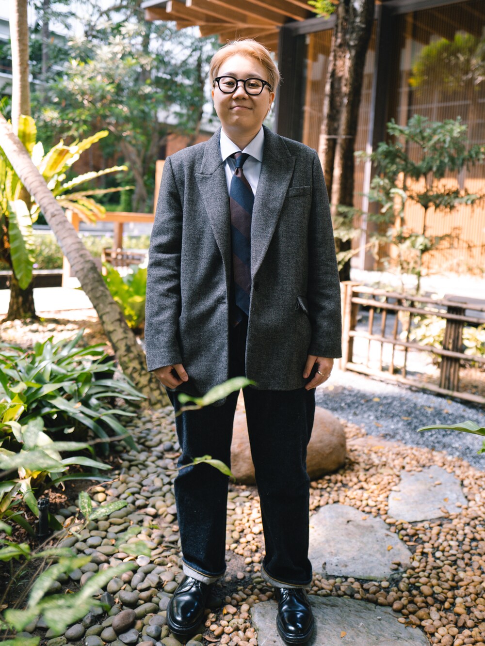 ブラウン系のネクタイ、ブラック系のドレスシューズ、ブルー系のデニムパンツを着用したレディースの冬コーディネートの3枚目の写真