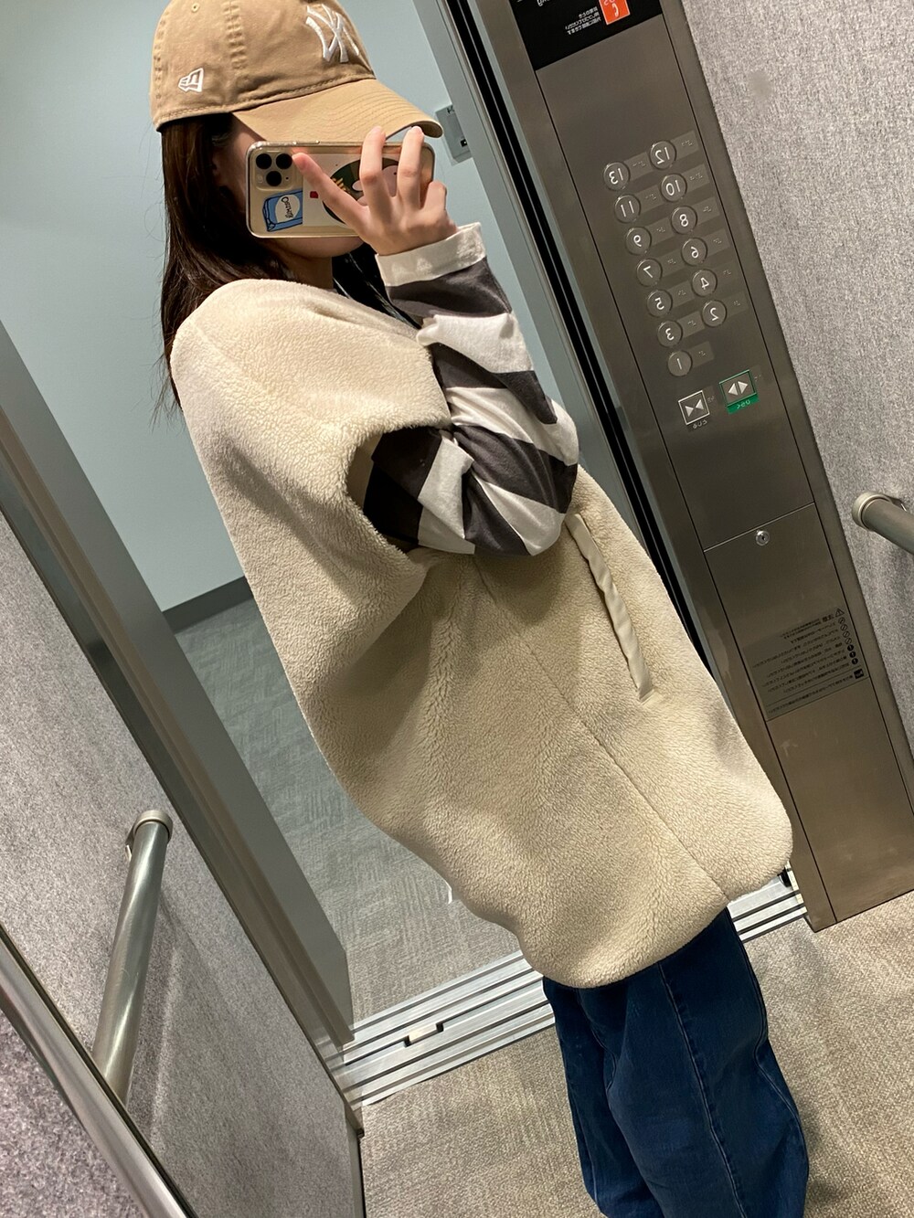 ブルー系のデニムパンツ、ベージュ系のブルゾン、その他のTシャツ/カットソーを着用したレディースの秋コーディネートの2枚目の写真