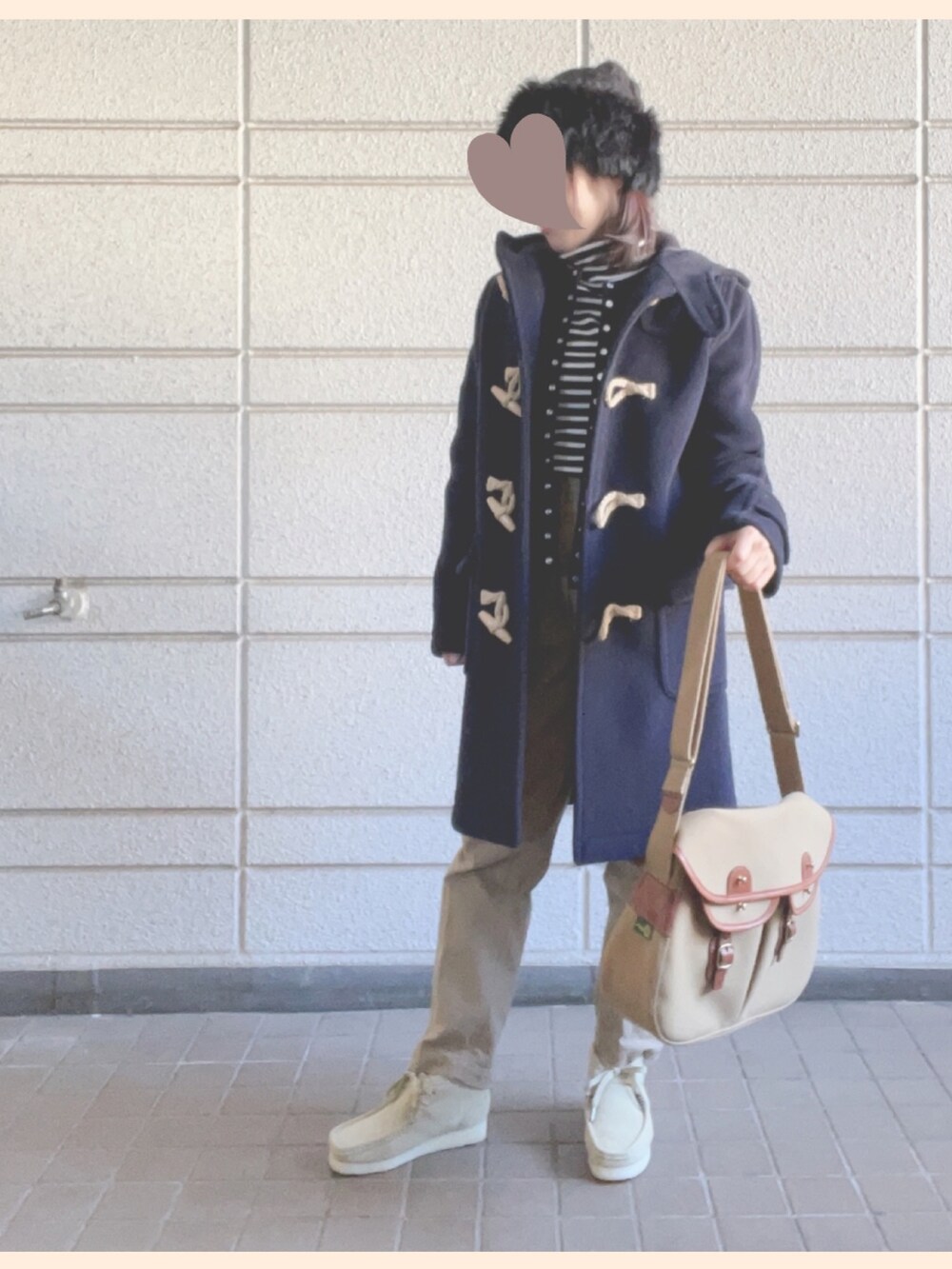 ベージュ系のショルダーバッグ、ブラック系のカーディガン/ボレロ、ベージュ系のブーツを着用したレディースの冬コーディネートの3枚目の写真