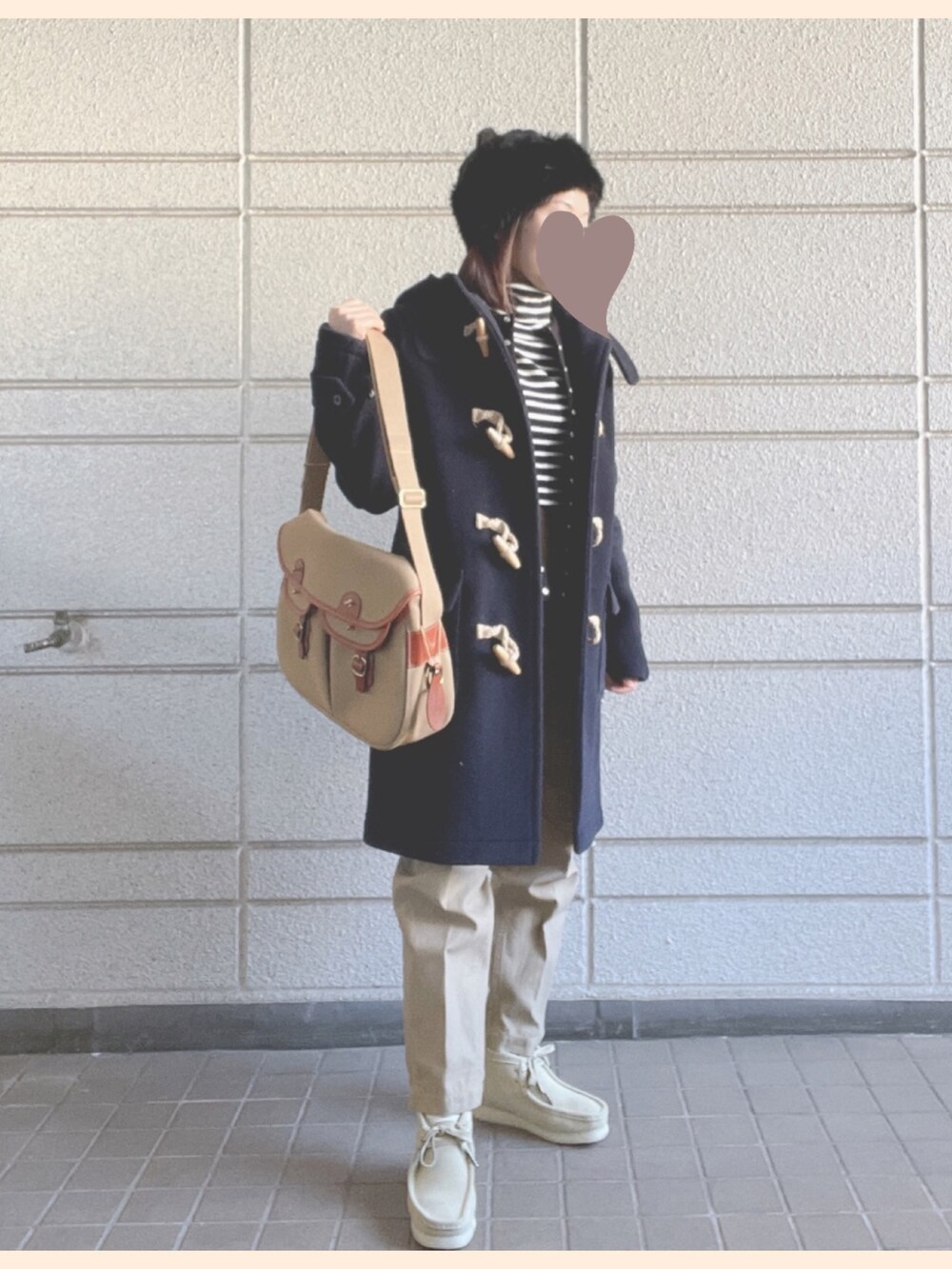 ベージュ系のショルダーバッグ、ブラック系のカーディガン/ボレロ、ベージュ系のブーツを着用したレディースの冬コーディネートの2枚目の写真