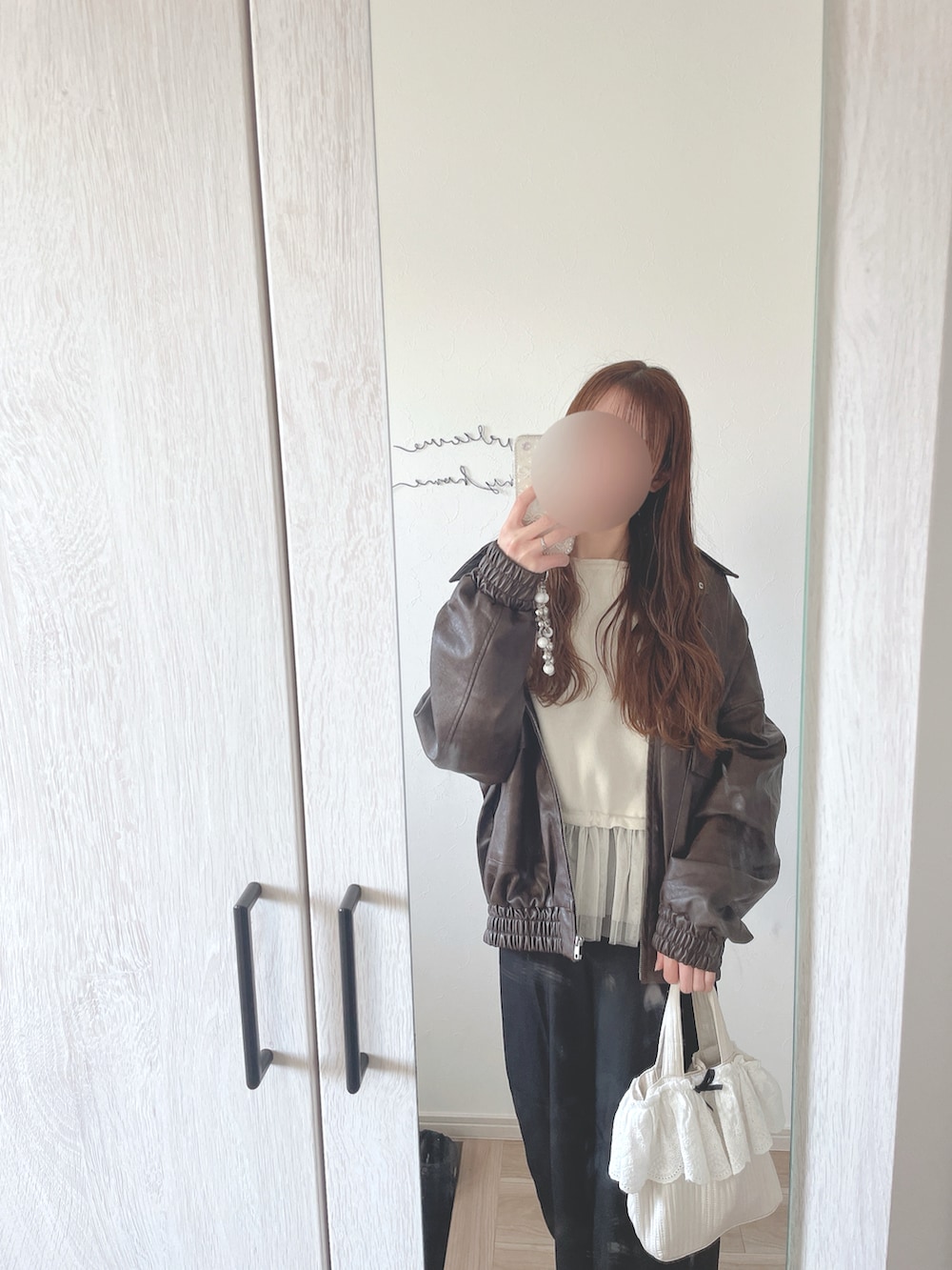 ホワイト系のニット/セーター、ブラウン系のジャケット/アウター、ブラック系のスラックスを着用したレディースの春コーディネートの2枚目の写真