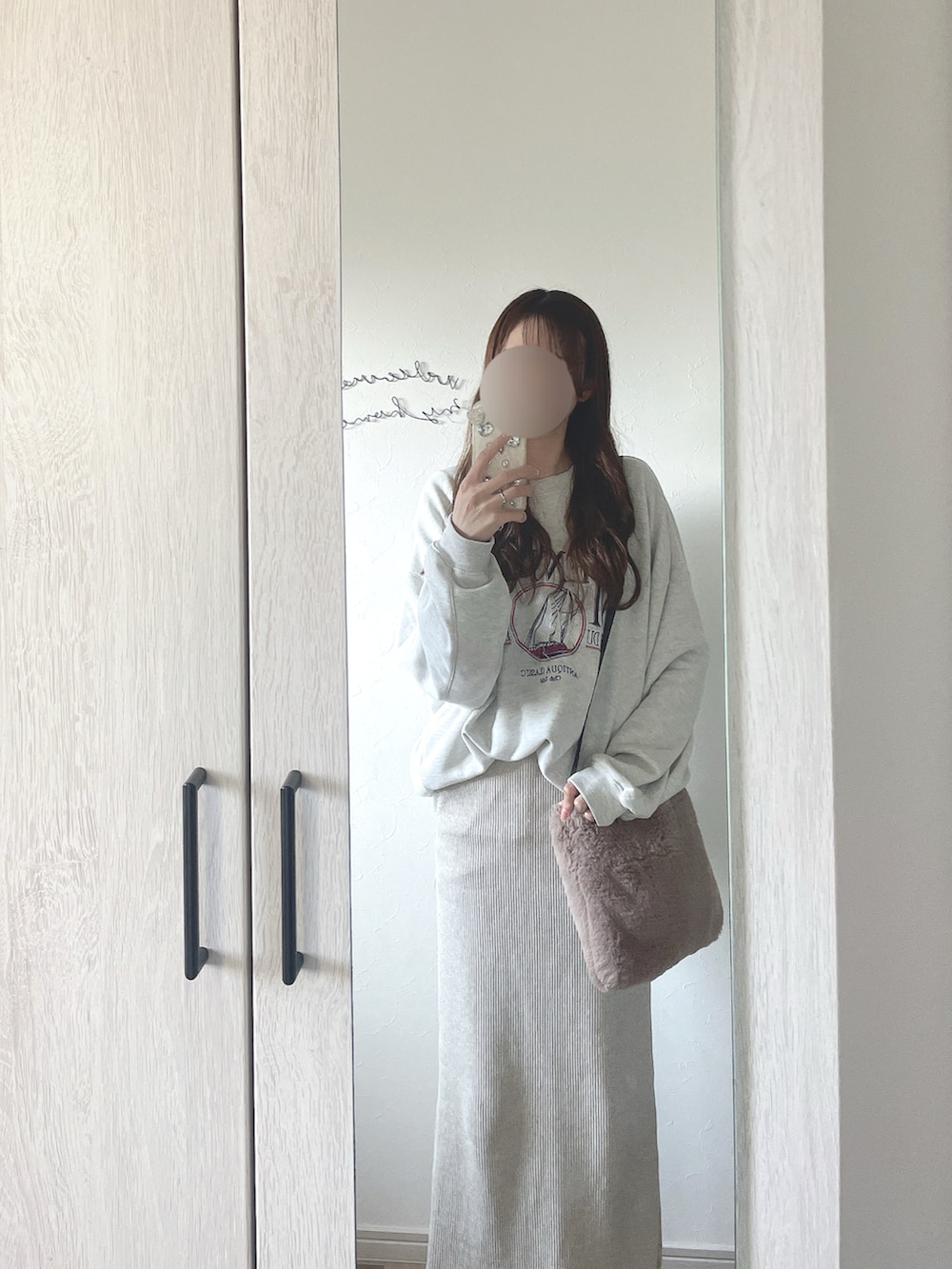 ベージュ系のスカート、ベージュ系のスウェット、ブラウン系のモカシン/デッキシューズを着用したレディースの秋コーディネートの2枚目の写真