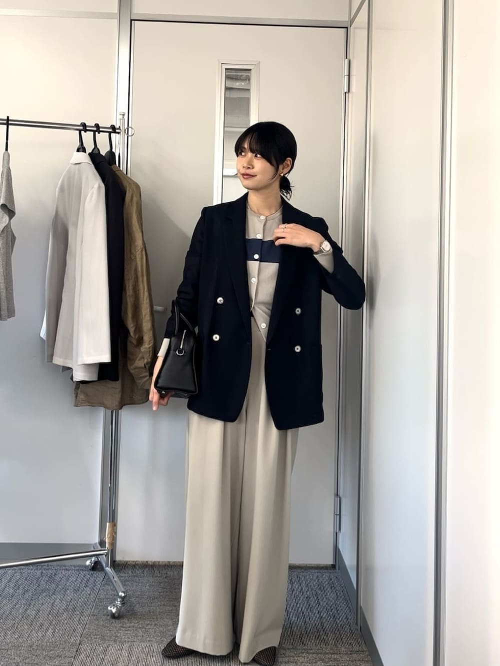 ブルー系のテーラードジャケット、グレー系のスラックスを着用したレディースの春コーディネートの2枚目の写真