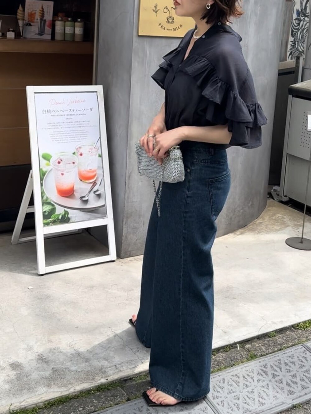 ブラック系のシャツ/ブラウス、ブルー系のデニムパンツを着用したレディースの夏コーディネートの4枚目の写真