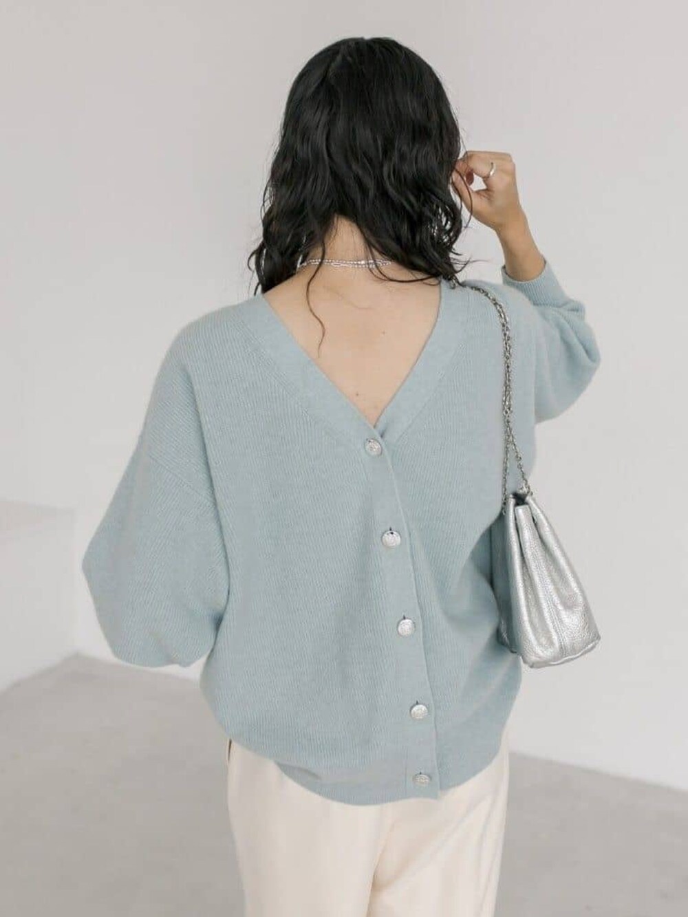 シルバー系のショルダーバッグ、ホワイト系のその他パンツ、ブルー系のカーディガン/ボレロを着用したレディースの冬コーディネートの4枚目の写真