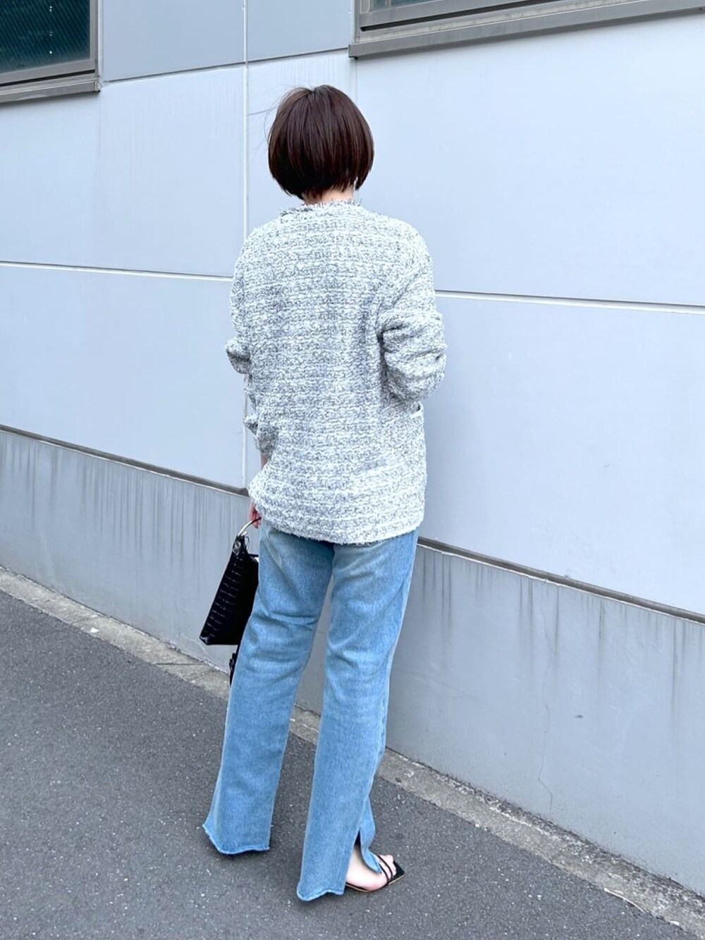 ブルー系のデニムパンツ、グレー系のカーディガン/ボレロを着用したレディースの春コーディネートの3枚目の写真