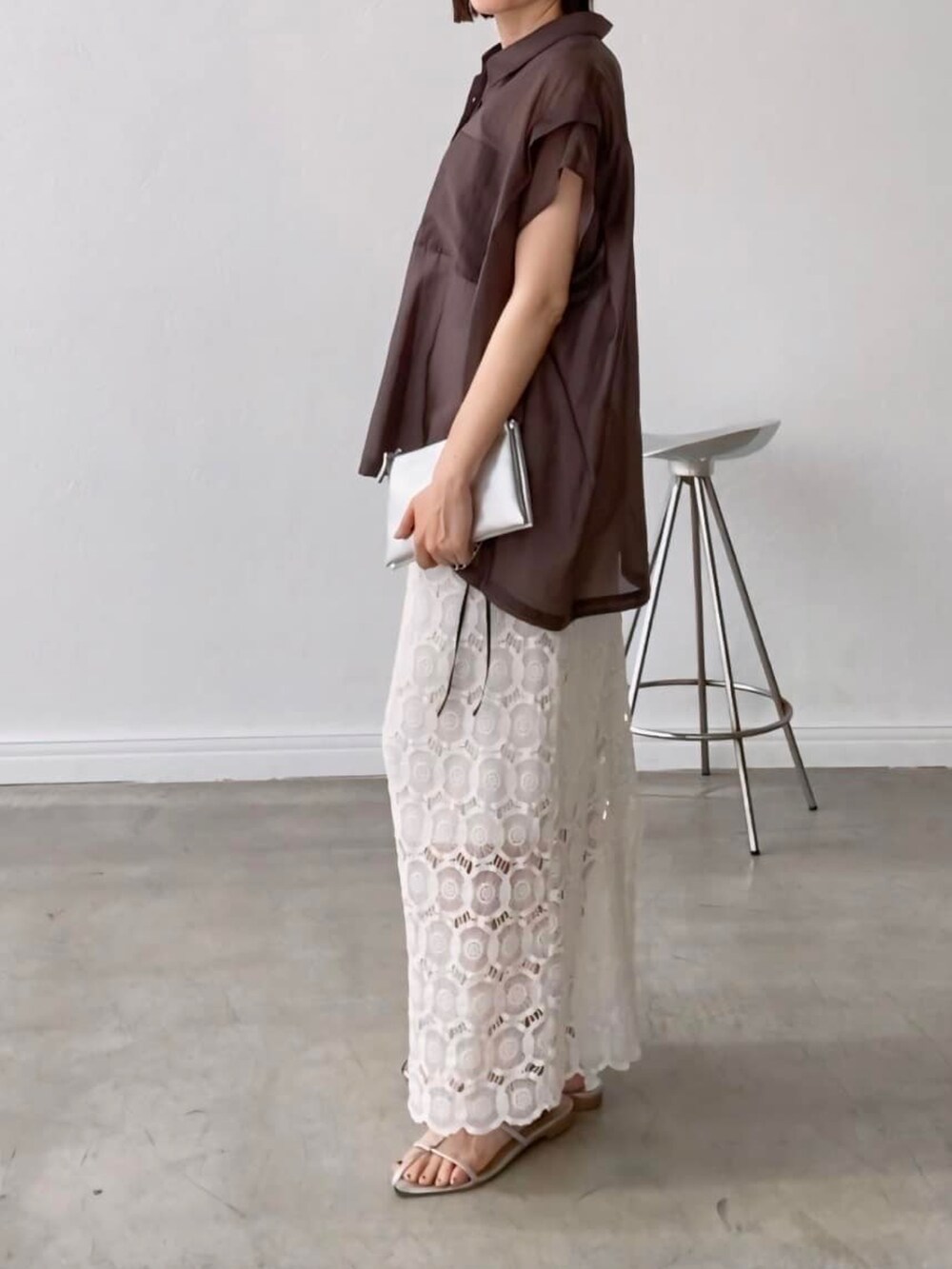 ホワイト系のスカート、シルバー系のショルダーバッグ、シルバー系のサンダルを着用したレディースの春コーディネートの3枚目の写真