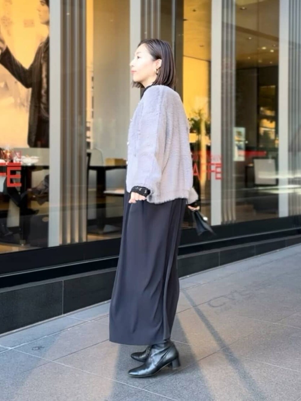 ホワイト系のTシャツ/カットソー、グレー系のカーディガン/ボレロ、ブラック系のワンピースを着用したレディースの冬コーディネートの4枚目の写真