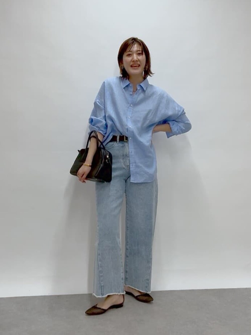 ブルー系のデニムパンツ、ブルー系のシャツ/ブラウス、ブラック系のパンプスを着用したレディースの冬コーディネートの4枚目の写真