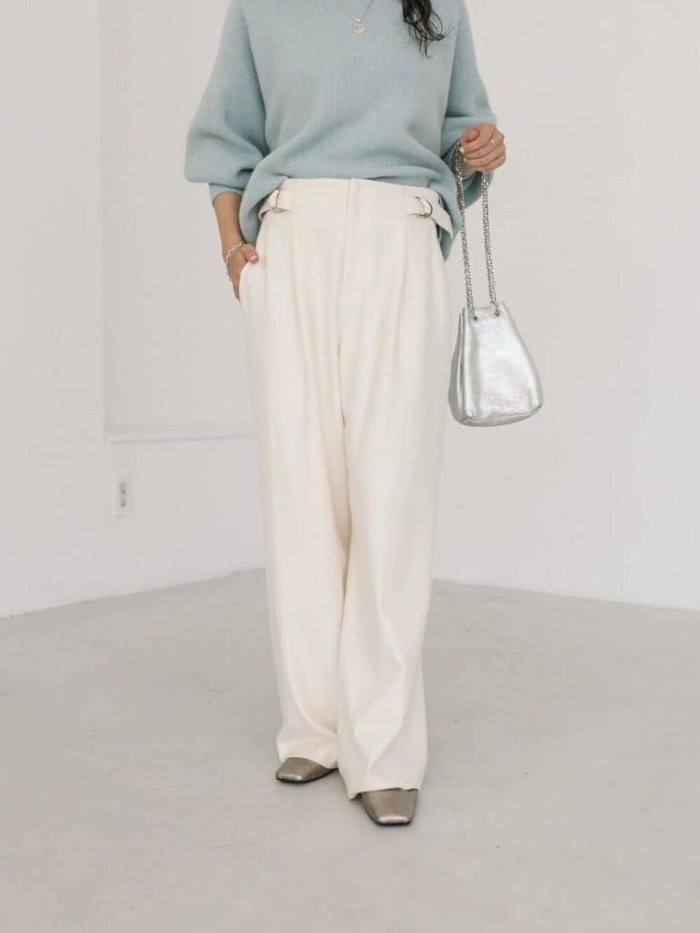 シルバー系のショルダーバッグ、ホワイト系のその他パンツ、ブルー系のカーディガン/ボレロを着用したレディースの冬コーディネートの5枚目の写真