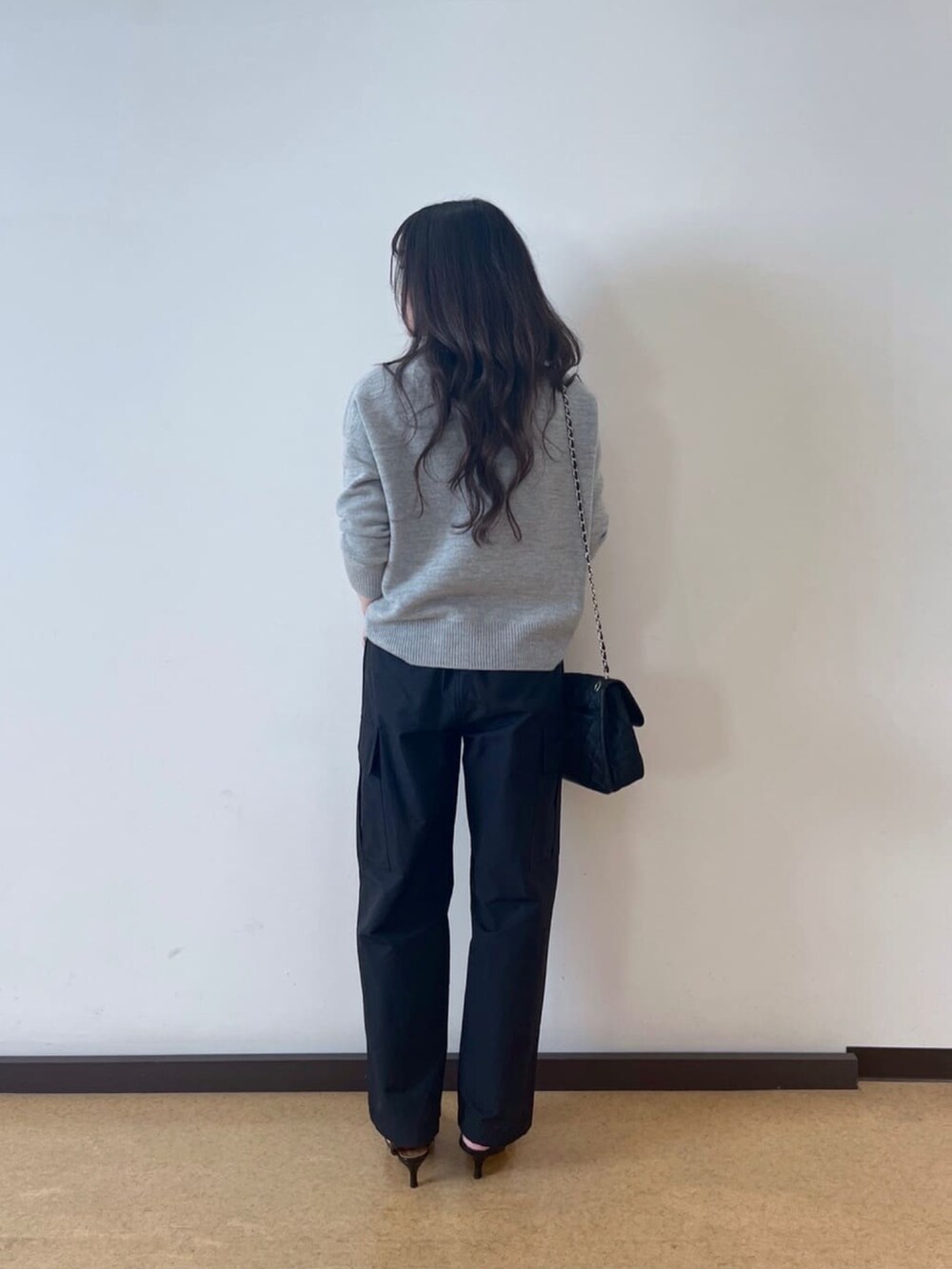 ブラック系のカーゴパンツ、グレー系のニット/セーター、ブラック系のパンプスを着用したレディースの秋コーディネートの3枚目の写真