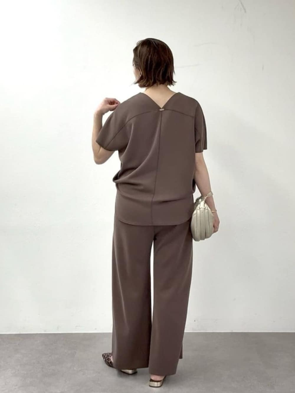 ベージュ系のその他シューズ、ゴールド系のショルダーバッグ、ブラウン系のその他パンツを着用したレディースの春コーディネートの3枚目の写真