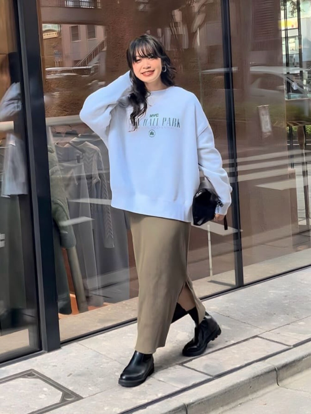 ブラック系のダウンジャケット/コート、グレー系のスウェット、ブラック系のワンピースを着用したレディースの秋コーディネートの4枚目の写真