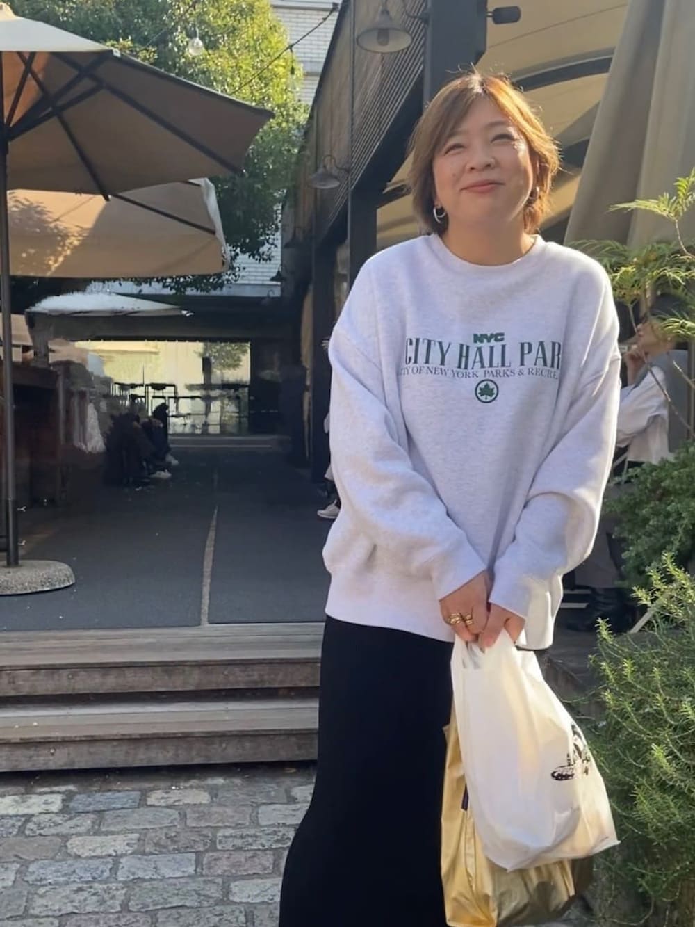 ブラック系のスカート、グレー系のスウェットを着用したレディースの秋コーディネートの2枚目の写真