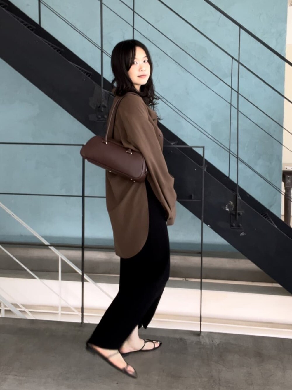 ブラック系のワンピース、ブラウン系のシャツ/ブラウス、ブラック系のサンダルを着用したレディースの夏コーディネートの2枚目の写真