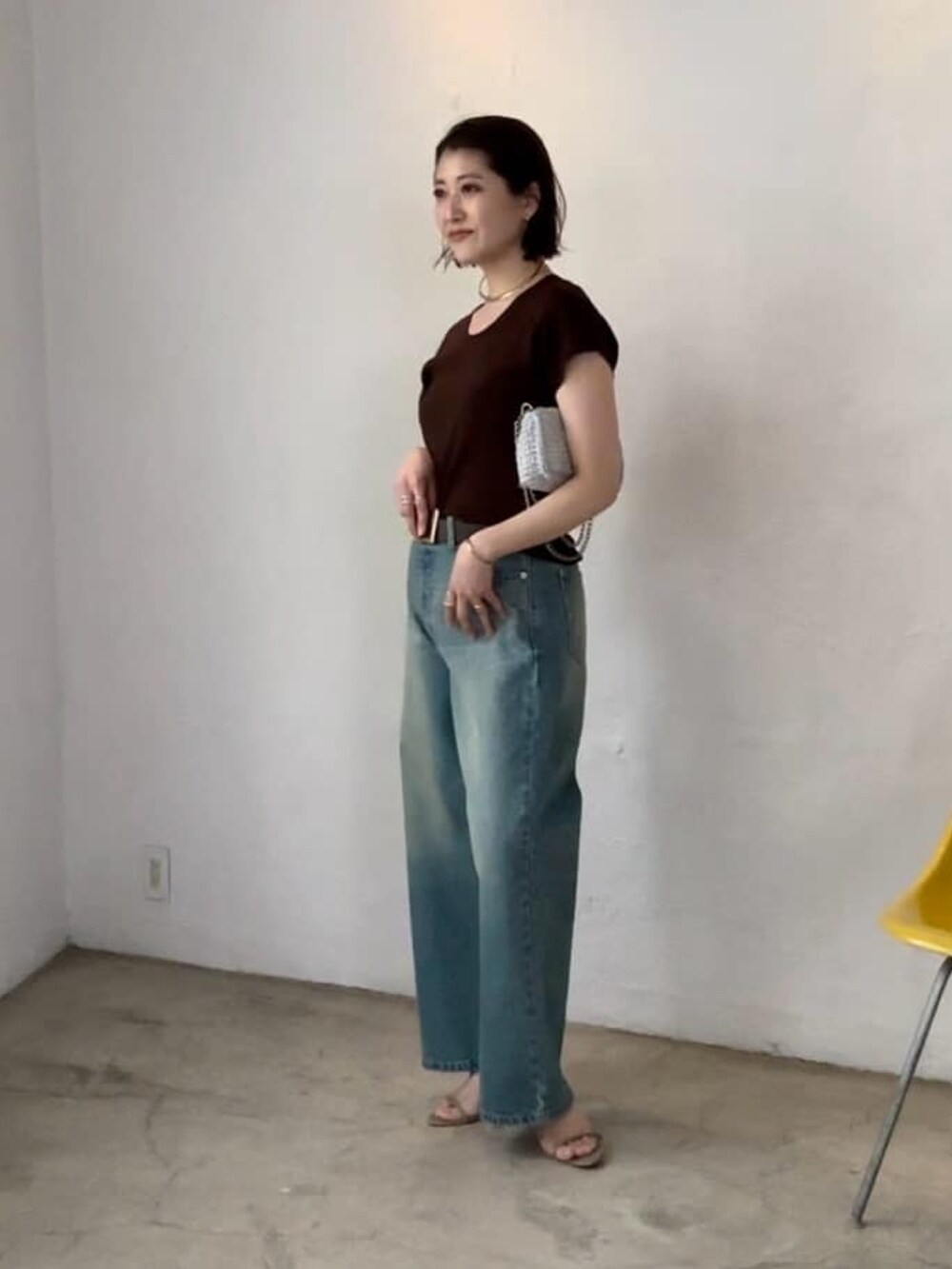 ホワイト系のニット/セーター、ブルー系のデニムパンツ、グレー系のサンダルを着用したレディースの春コーディネートの3枚目の写真