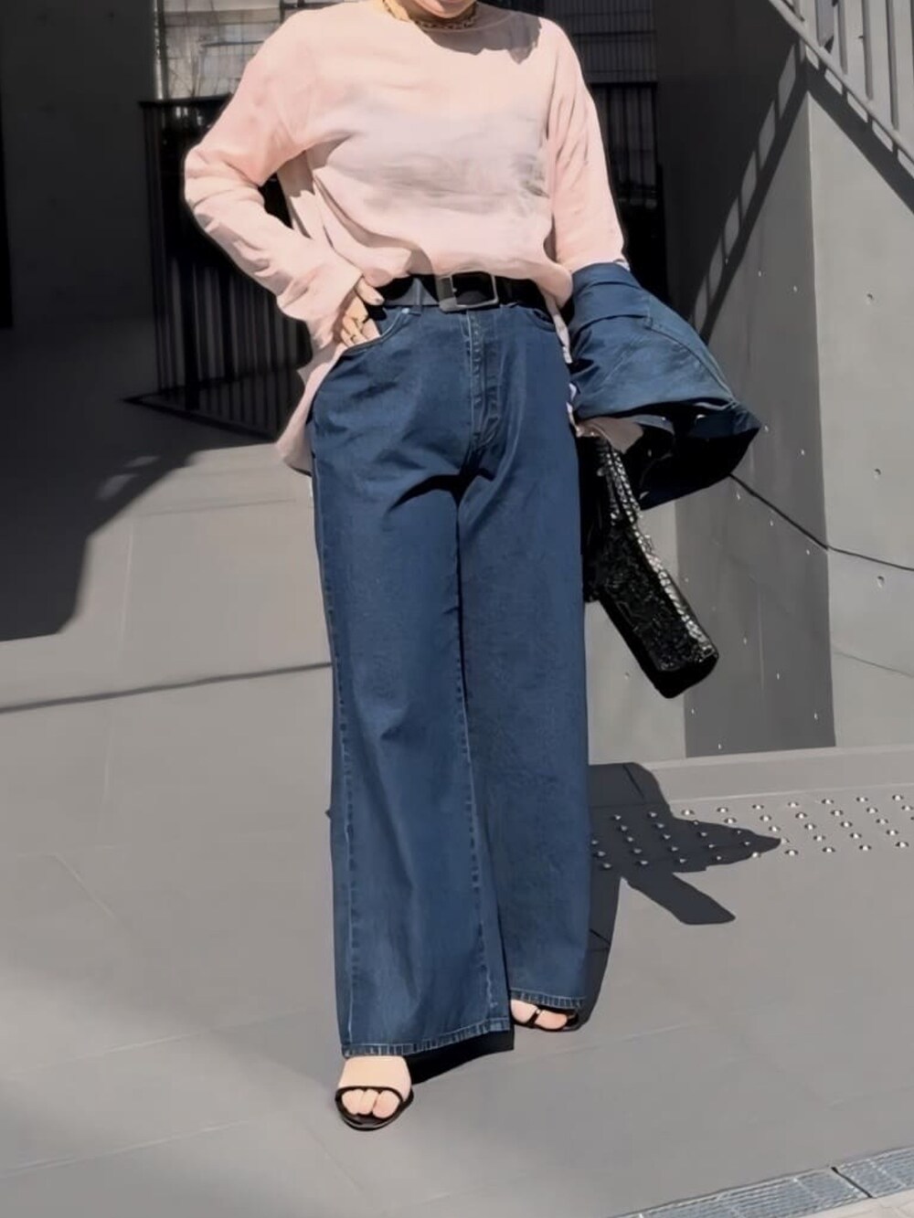 ピンク系のシャツ/ブラウス、ブラック系のショルダーバッグ、ブルー系のデニムパンツを着用したレディースの春コーディネートの4枚目の写真