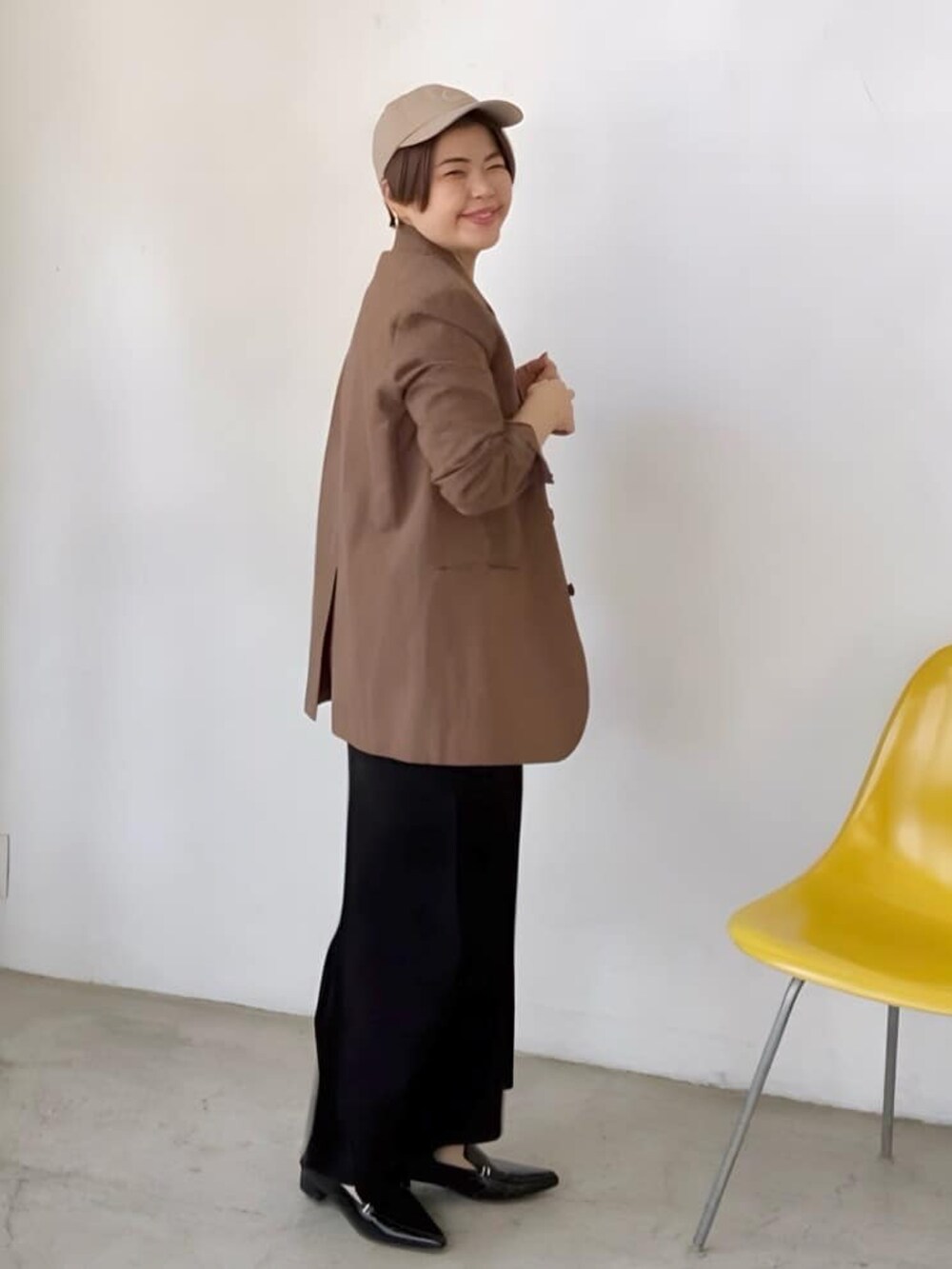 ブラウン系のテーラードジャケット、ブラック系のワンピース、ブラック系のローファーを着用したレディースの春コーディネートの2枚目の写真