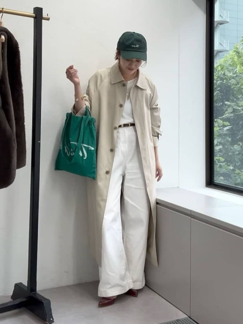 ホワイト系のデニムパンツ、レッド系のパンプス、ベージュ系のステンカラーコートを着用したレディースの夏コーディネートの2枚目の写真