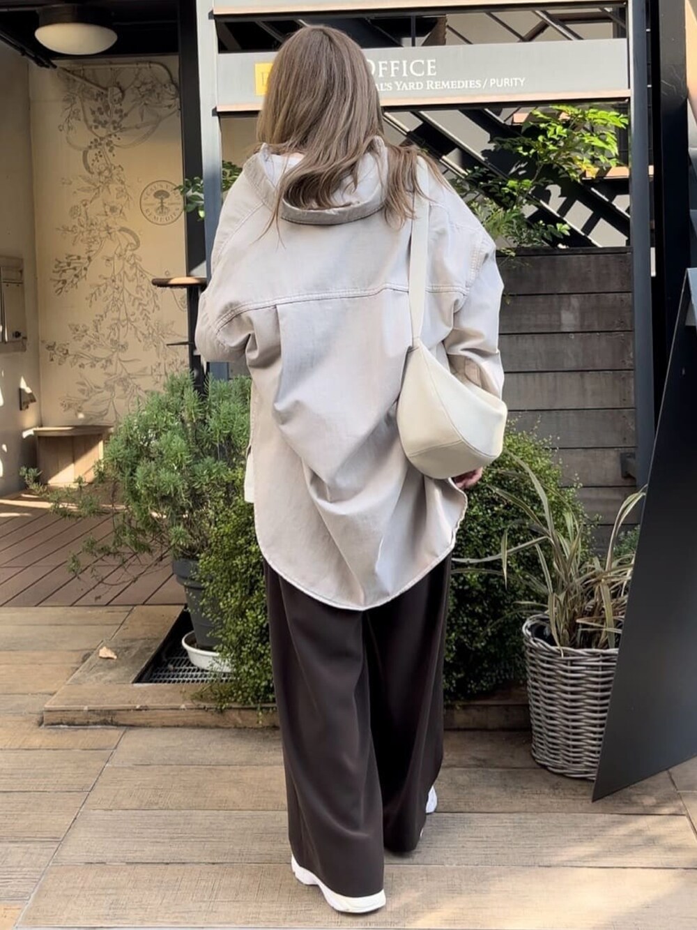 グレー系のシャツ/ブラウス、ホワイト系のTシャツ/カットソー、ブラウン系のスラックスを着用したレディースの秋コーディネートの3枚目の写真