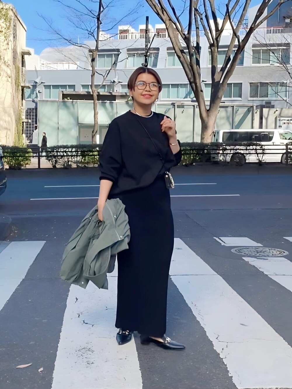 グレー系のスカート、ブラック系のTシャツ/カットソー、ブラック系のローファーを着用したレディースの冬コーディネートの4枚目の写真