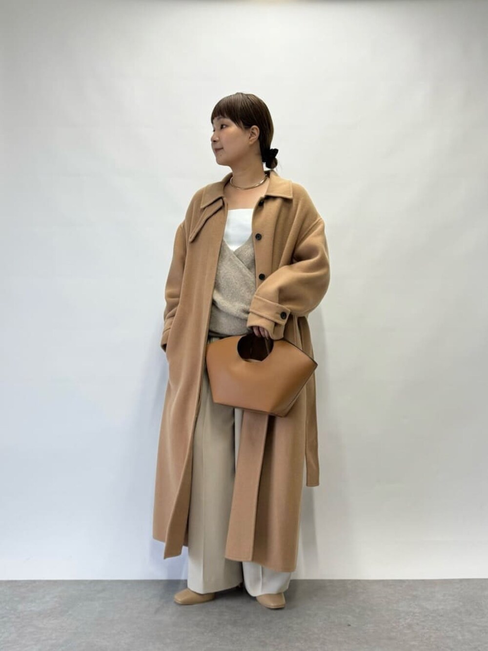 ブラウン系のニット/セーター、イエロー系のその他アウター、シルバー系のチョーカーを着用したレディースの秋コーディネートの2枚目の写真