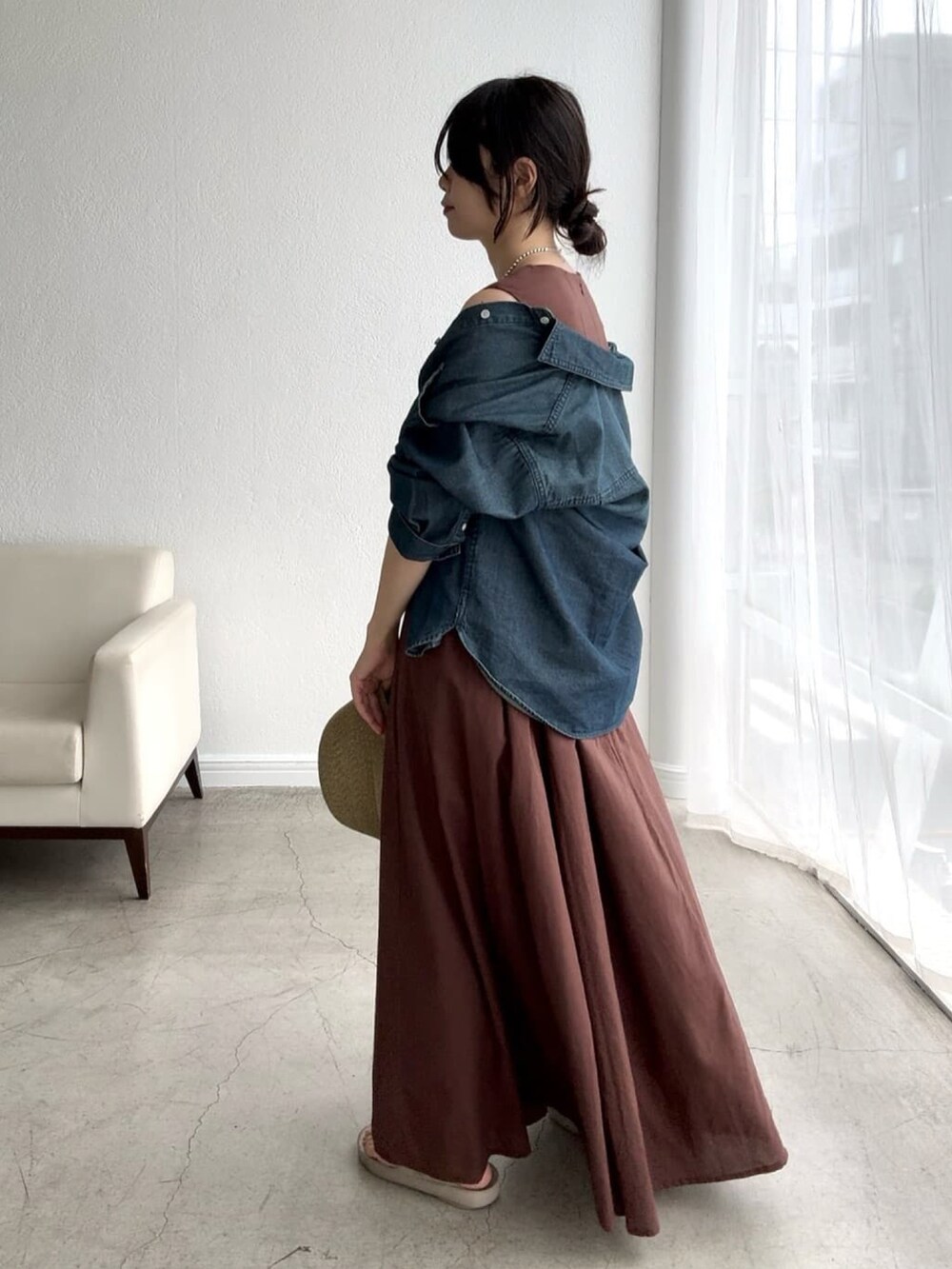 ブラウン系のワンピース、ブルー系のシャツ/ブラウスを着用したレディースの春コーディネートの2枚目の写真