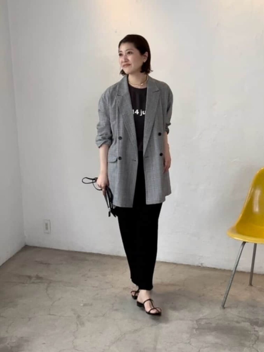 グレー系のテーラードジャケット、ブラック系のスカート、ブラック系のサンダルを着用したレディースの春コーディネートの3枚目の写真