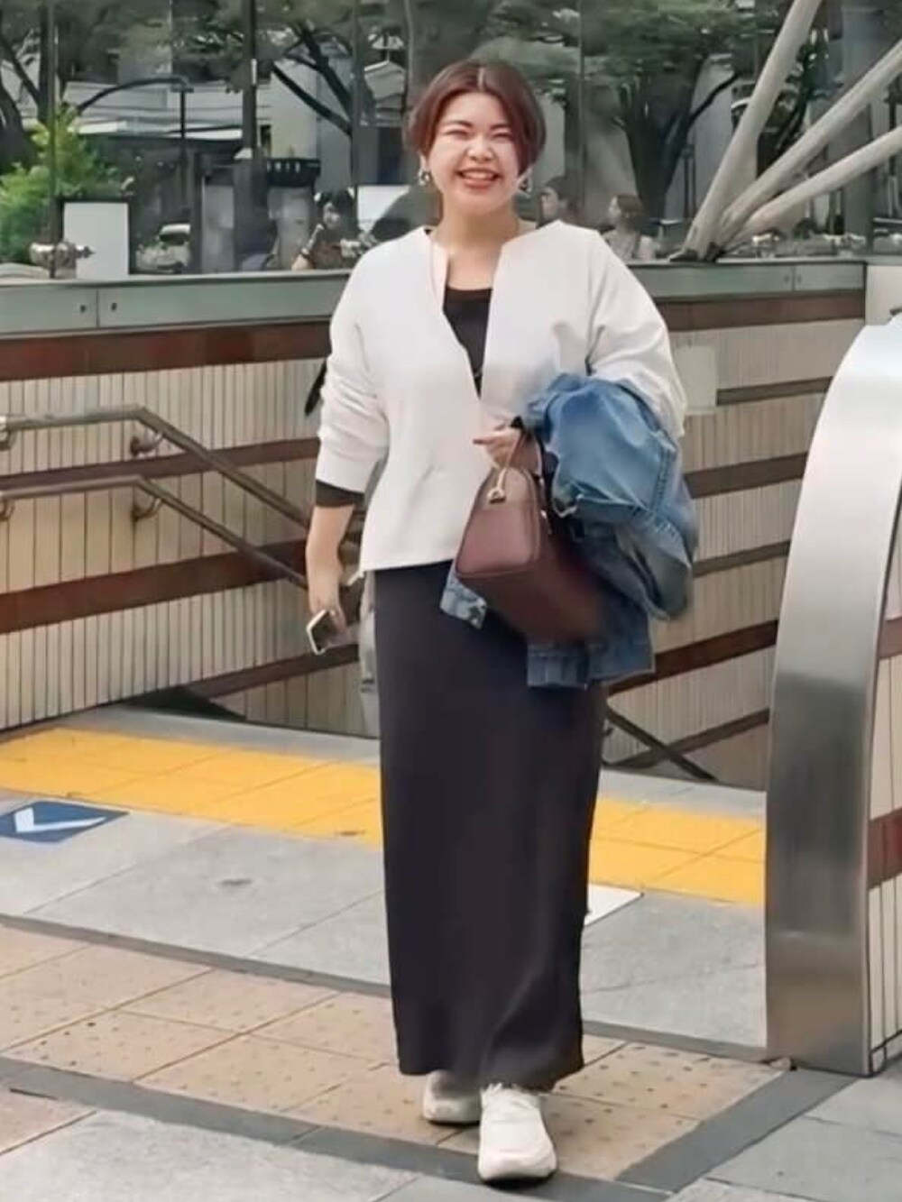 ホワイト系のスウェット、ブルー系のデニムジャケット、ブラック系のワンピースを着用したレディースの冬コーディネートの2枚目の写真