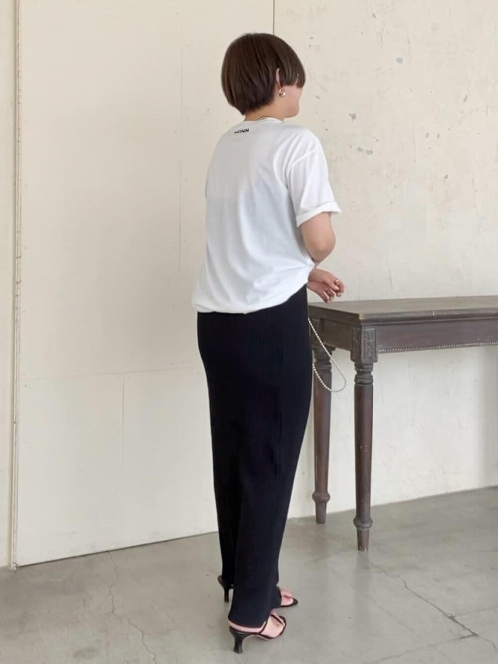 ブラック系のTシャツ/カットソー、ブラック系のスカート、ブラック系のサンダルを着用したレディースの夏コーディネートの2枚目の写真