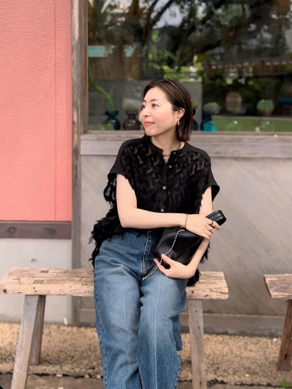 ブラック系のシャツ/ブラウス、ブラック系のサンダル、ブルー系のデニムパンツを着用したレディースの夏コーディネートの5枚目の写真