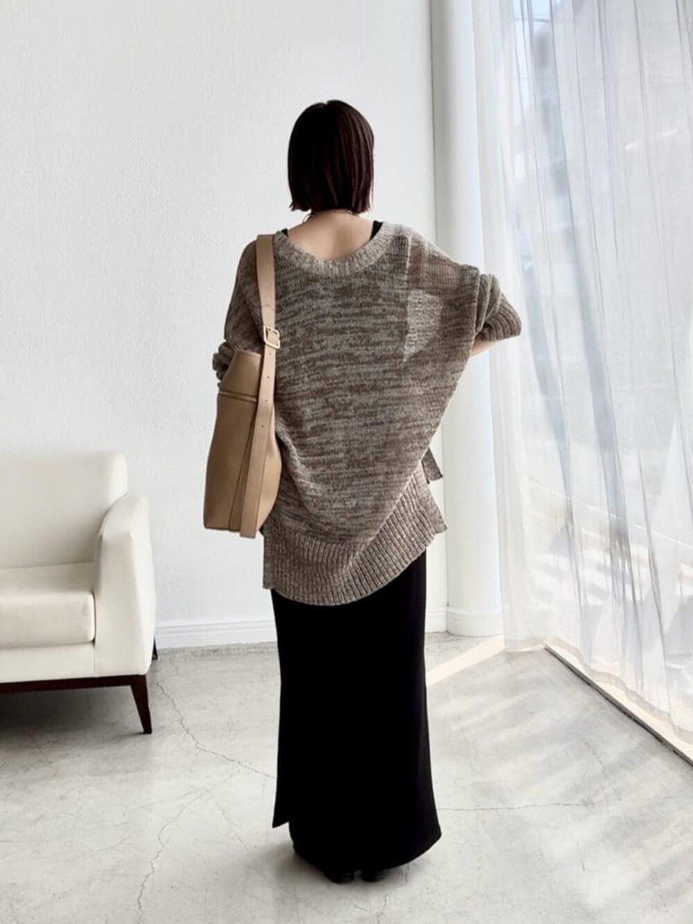 ブラウン系のカーディガン/ボレロ、ブラック系のワンピース、ブラック系のサンダルを着用したレディースの夏コーディネートの3枚目の写真