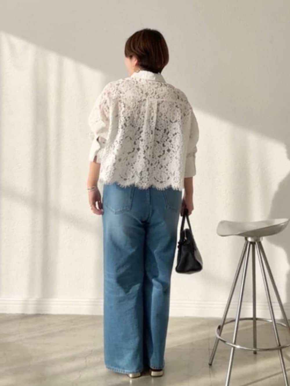 ブラック系のボストンバッグ、ブルー系のデニムパンツ、ベージュ系のその他シューズを着用したレディースの春コーディネートの2枚目の写真