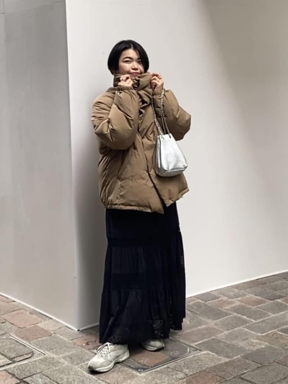 レッド系のニット/セーター、ブラック系のスカート、ブラウン系のダウンジャケット/コートを着用したレディースの冬コーディネートの3枚目の写真